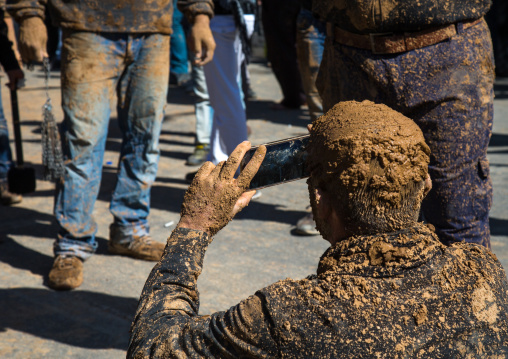 Iranian Shiite Muslim Man Covered In Mud Taking Pictures With A Mobile Phone During Ashura Day, Kurdistan Province, Bijar, Iran