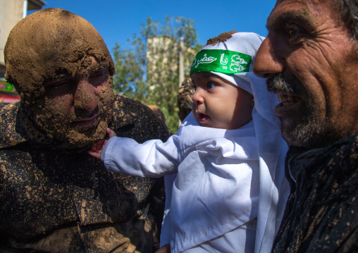 Iranian Shiite Baby Touching The Beard Of A Man Covered In Mud During Ashura Day, Kurdistan Province, Bijar, Iran