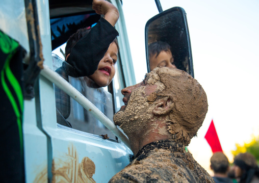 Iranian Shiite Muslim Man Covered In Mud Speaking To A Boy In A Truck During Ashura Day, Kurdistan Province, Bijar, Iran
