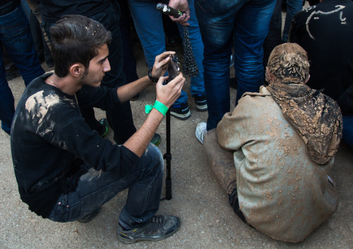 Iranian Shiite Muslim Man Covered In Mud Taking Pictures During Ashura Day, Kurdistan Province, Bijar, Iran