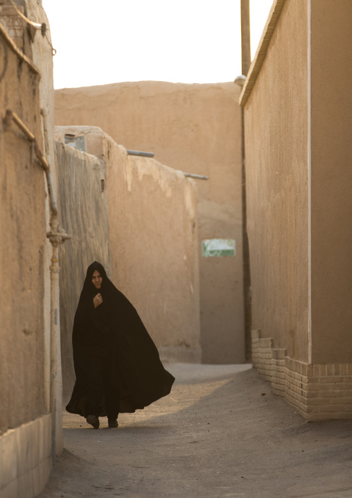 A Muslim Woman Walking Alone In A Narrow Street, Isfahan Province, Kashan, Iran