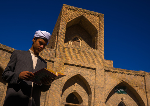 Iranian Shiite Student In The Courtyard Of An Old Caravanserai Turned Into Madrassah Reading The Koran, Golestan Province, Karim Ishan, Iran