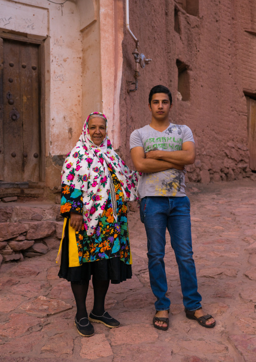 Portrait Of An Iranian Woman Wearing Traditional Floreal Chador With Her Son In Zoroastrian Village, Isfahan Province, Abyaneh, Iran