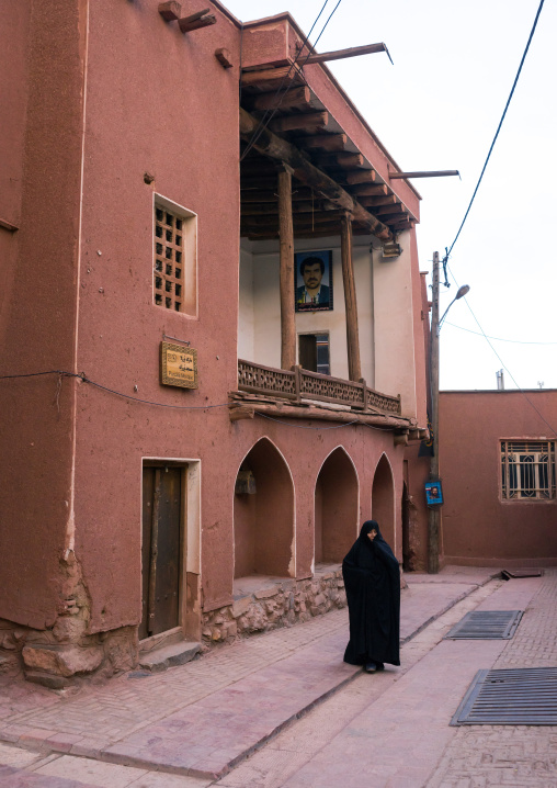 Iranian Woman In Black Passing In Front Of An Ancient Building In Zoroastrian Village, Isfahan Province, Abyaneh, Iran