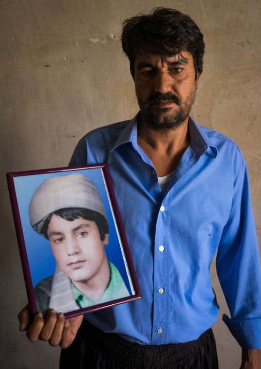 An Afghan Refugee Man Showing A Portrait Of Himself When He Was A Teenager, Isfahan Province, Kashan, Iran