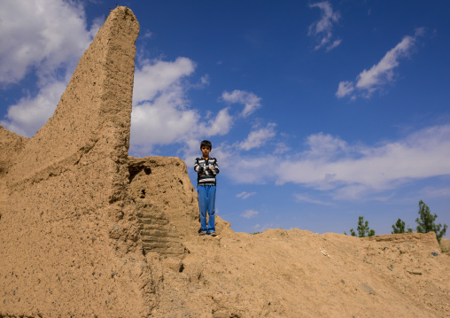 An Afghan Refugee Boy Standing On House Ruins In A Village, Isfahan Province, Kashan, Iran