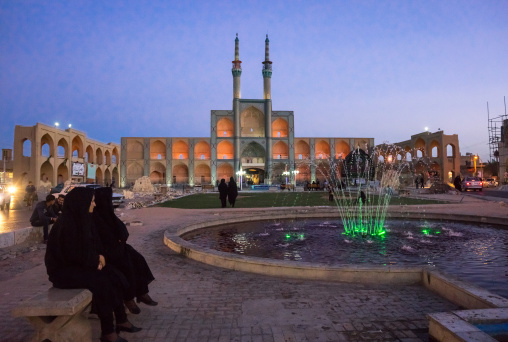 Iranian Women Sit In Front Of The Three-storey Takieh Which Forms Part Of The Amir Chakhmaq Complex, Yazd Province, Yazd, Iran