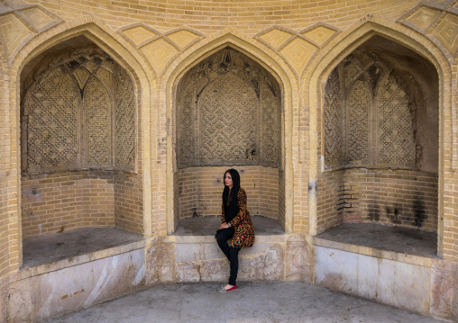 Iranian Veiled Woman Sitting On A Stone Bench, Fars Province, Shiraz, Iran