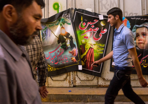 Men Passing In Front Of Ashura Banners Sold In The Bazaar, Fars Province, Shiraz, Iran