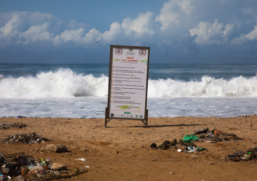 Garbage on the beach in front of a billboard to fight against pollution, Sud-Comoé, Grand-Bassam, Ivory Coast