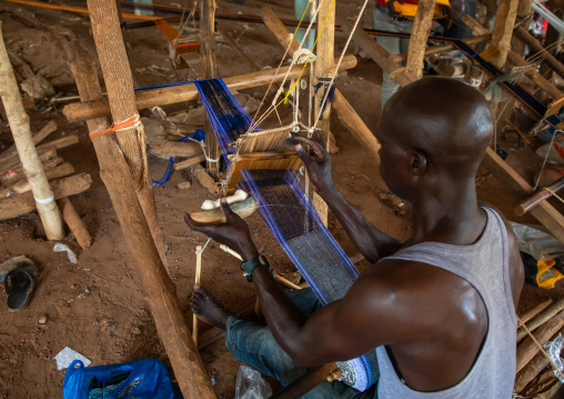 African man weaving in a traditional textile factory, Savanes district, Waraniene, Ivory Coast