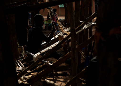 African man from Senufo tribe weaving in a traditional textile factory, Savanes district, Waraniene, Ivory Coast