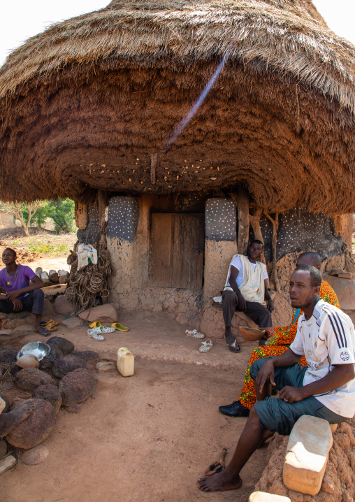 Senufo men sit in front of a fetish house whose roof gets a new layer every year, Savanes district, Niofoin, Ivory Coast