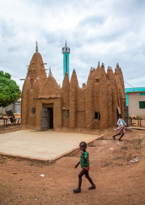 African children in front of a sudano-sahelian style mud mosque, Savanes district, Kouto, Ivory Coast