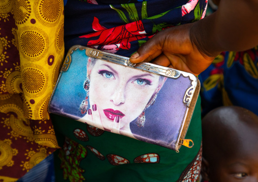 African woman holding a bag with the face of a caucasian woman printed on it, Bafing, Godoufouma, Ivory Coast