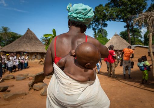 Dan tribe mother with her child during a ceremony, Bafing, Gboni, Ivory Coast