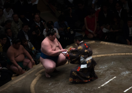 Sumo winner receiving his prize in the ryogoku kokugikan sumo arena, Kanto region, Tokyo, Japan