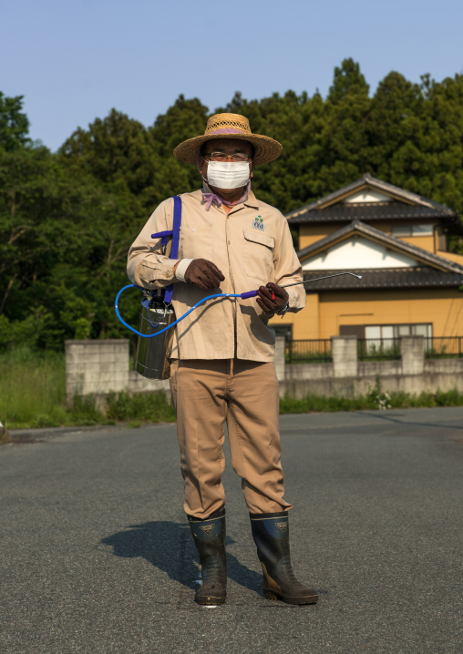 Man coming back in the contaminated area after the nuclear disaster to take care of his house and garden, Fukushima prefecture, Naraha, Japan