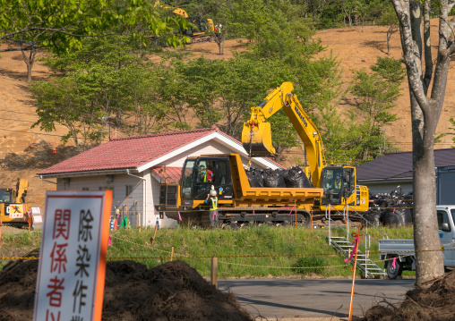 Decontamination work no entry sign in front of workers who remove top soil contaminated by nuclear radiations after the daiichi nuclear power plant explosion, Fukushima prefecture, Iitate, Ja