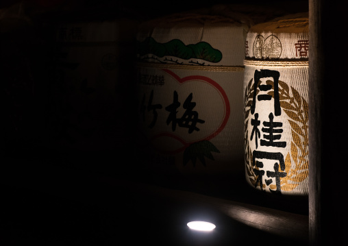 Large traditional sake barrels stacked up outside the temple wall fushimi inari taisha, Kansai region, Kyoto, Japan