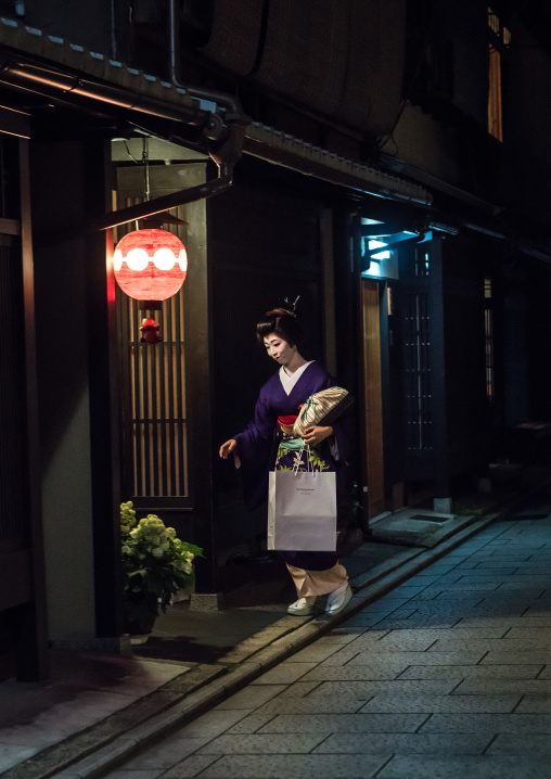 Geisha in the streets of gion going inside a house, Kansai region, Kyoto, Japan
