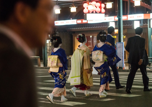 Geishas with businessmen in the streets of gion, Kansai region, Kyoto, Japan
