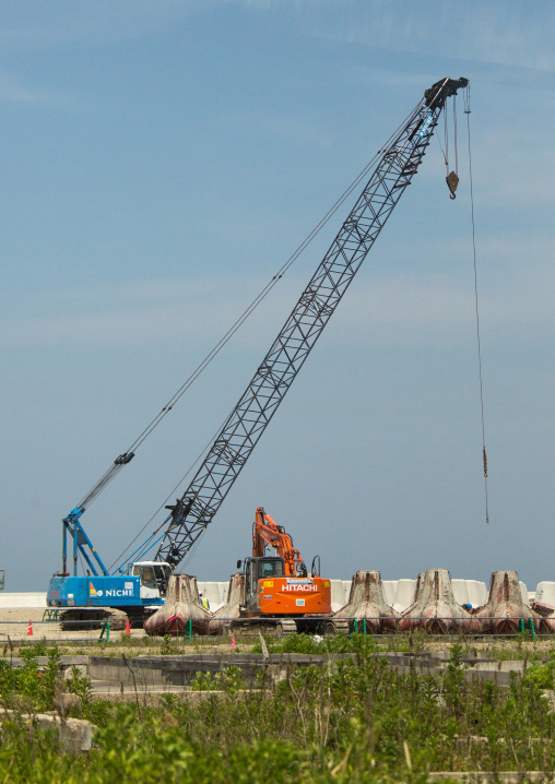 Cranes putting tetrapods on a beach, Fukushima prefecture, Namie, Japan