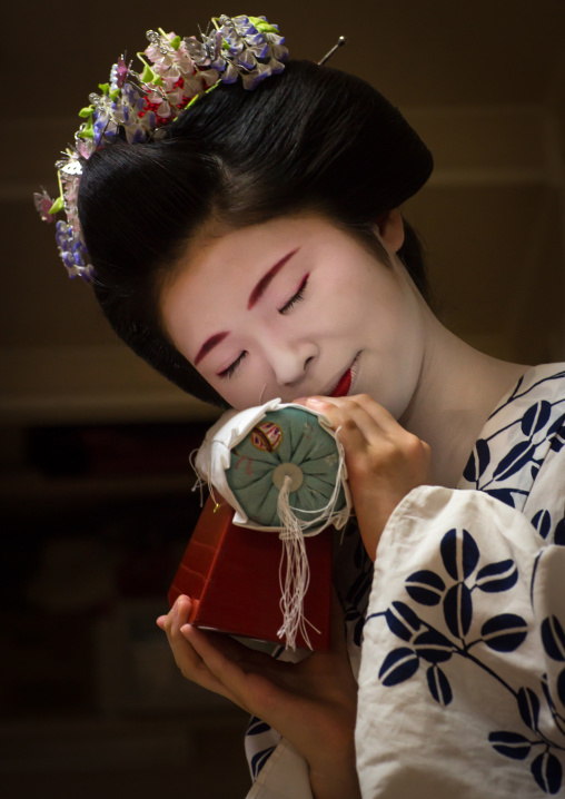 16 Years old maiko called chikasaya with the pillow shes used to protect her hairstyle, Kansai region, Kyoto, Japan