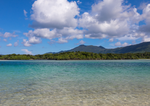 Tropical lagoon with clear blue water surrounded by lush greenery in Kabira bay, Yaeyama Islands, Ishigaki, Japan