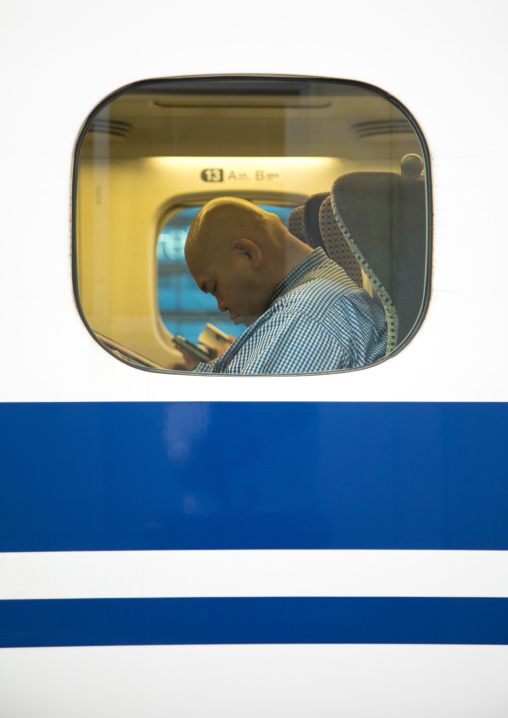 Passenger sleeping inside a Shinkansen train, Hypgo Prefecture, Himeji, Japan