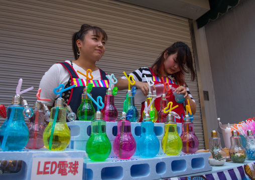 Women selling fruits cocktails in former light bulbs in the street, Kansai region, Osaka, Japan