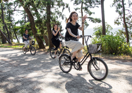Japanese women riding bicycles in Amanohashidate, Kyoto Prefecture, Miyazu, Japan