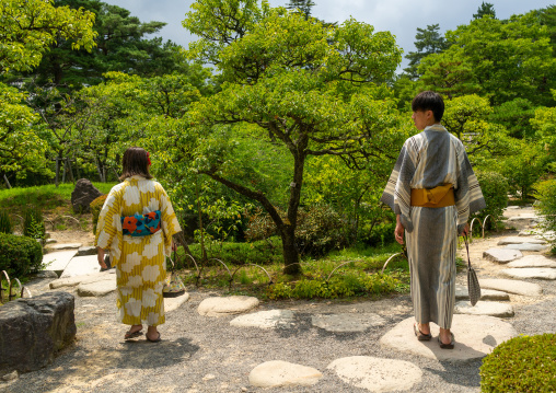Japanese couple in yukata visiting the plum grove in Kenroku-en garden, Ishikawa Prefecture, Kanazawa, Japan