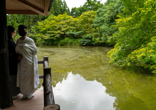 Newly-wed couple looking at the pond of the botanic garden, Kansai region, Kyoto, Japan