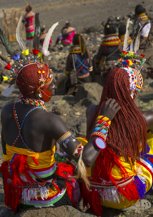 Rendille warrior taking care the ochred braided hair of a friend, Turkana lake, Loiyangalani, Kenya