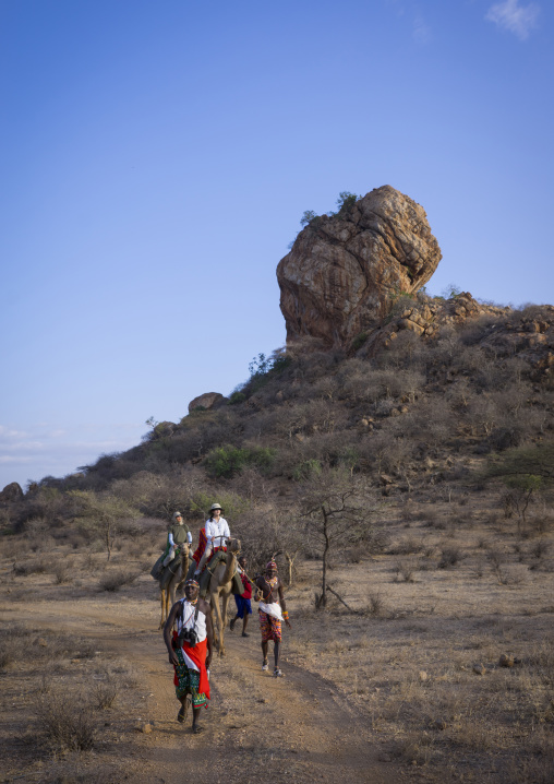 Rendille warrior in a trck with tourists riding camels, Samburu county, Samburu national reserve, Kenya