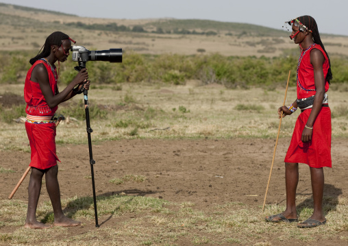 Maasai warrior taking a picture of another one with an Hasselblad camera, Rift Valley Province, Maasai Mara, Kenya