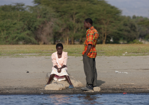 Couple chatting in front of a lake, Rift Valley Province, Lake Nakuru, Kenya