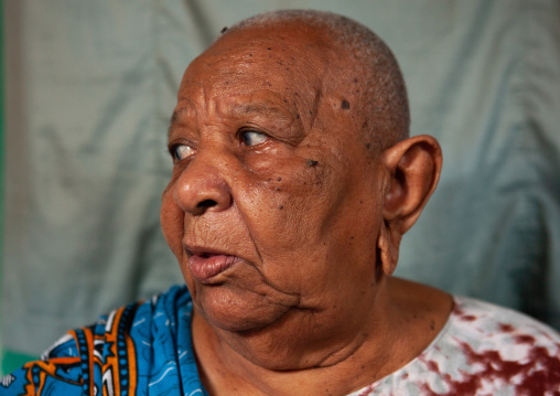 Portrait of a senior woman with shaved head and enlarged earlobes, Lamu County, Siyu, Kenya