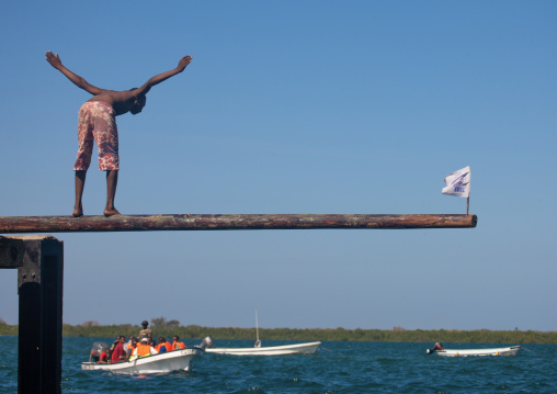 Men trying to keep balance for a competition during Maulid festival, Lamu County, Lamu, Kenya