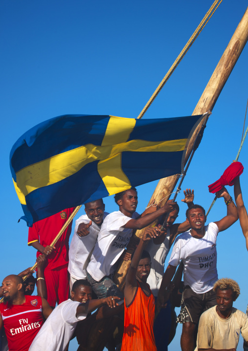 Swedish flagged dhow with crew cheering themselves, Lamu County, Lamu, Kenya