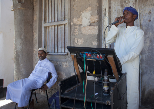 Muslim man speaking in a microphone during Maulid festival in the street, Lamu County, Lamu, Kenya