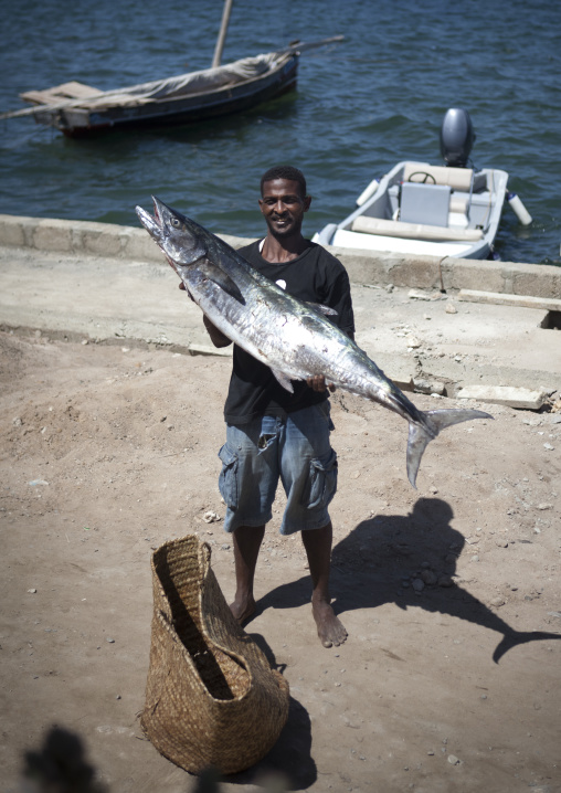 Man on the dockside with an big fish, Lamu County, Lamu, Kenya