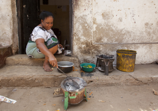Kenyan woman cooking in the street, Lamu County, Lamu, Kenya
