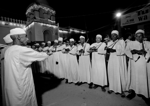 Muslim men singing and dancing with goma sticks during Maulid festival, Lamu County, Lamu, Kenya