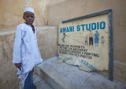 Muslim child standing near a photographer sign in a street, Lamu County, Lamu, Kenya