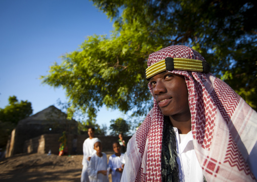 Muslim teenage boy wearing keffieh during the procession of the Maulid festival, Lamu County, Lamu, Kenya