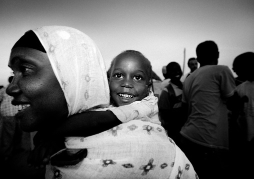 Boy on back of a muslim woman during Maulid festival, Lamu County, Lamu, Kenya