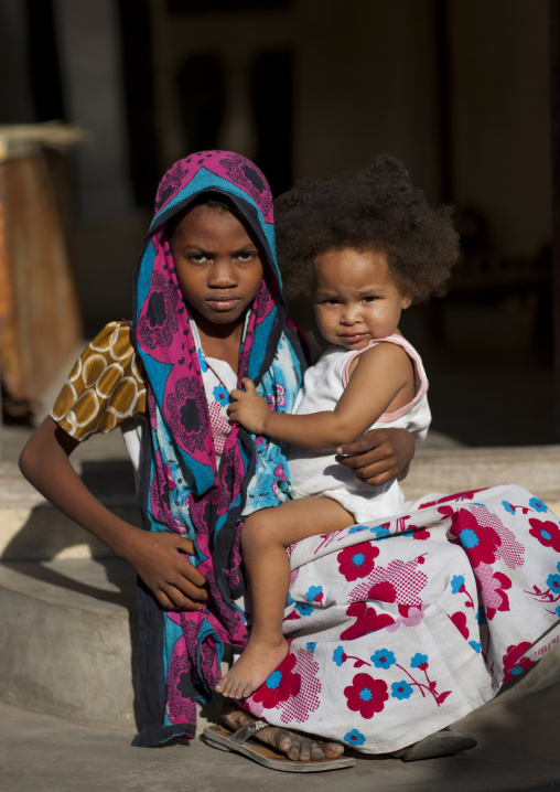 Muslim teenage girl holding a little girl, Lamu County, Matondoni, Kenya