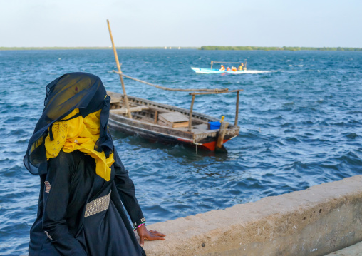 Muslim woman in burqa looking at the sea, Lamu county, Lamu town, Kenya